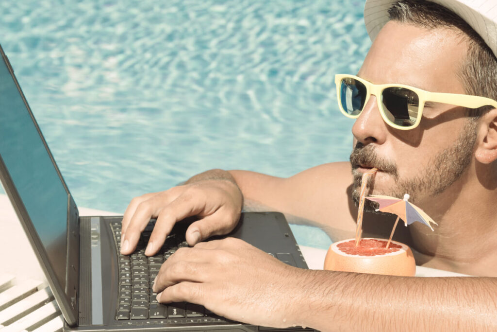 man on laptop while in pool researching refinancing home loan